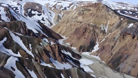 Drohnenansicht-Von-Oben-Nach-Unten-über-Die-Rhyolithberge-Von-Landmannalaugar-Im-Brandsgil-Tal,-Die-Sommerlandschaften-Mit-Schneeresten-Einfangen