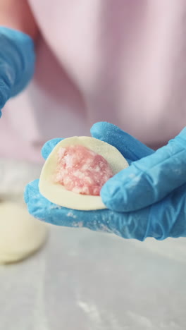 close-up of hands in blue gloves preparing or decorating pastries/desserts.