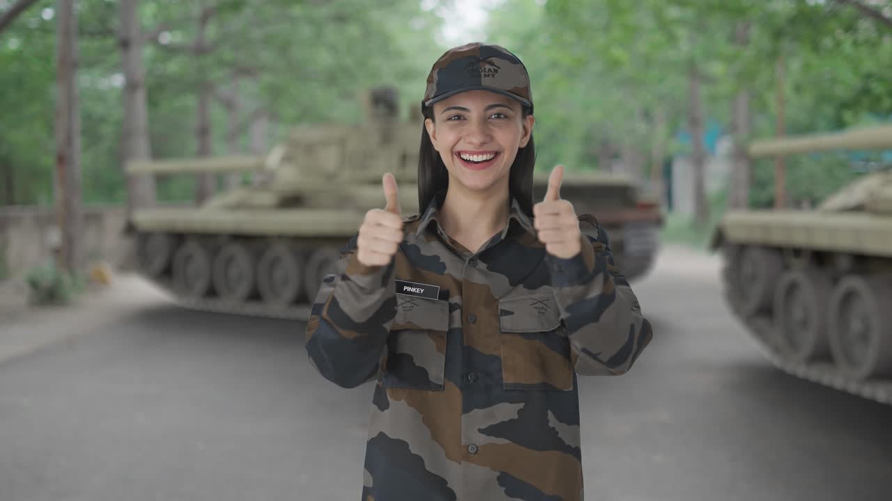 mujer india feliz oficial del ejército mostrando los pulgares hacia arriba