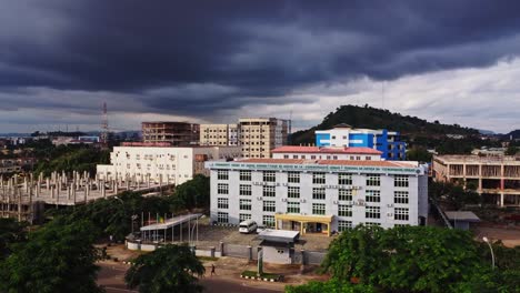 aerial view of the ecowas court of justice in abuja, nigeria with dark ominous clouds above the cityscape