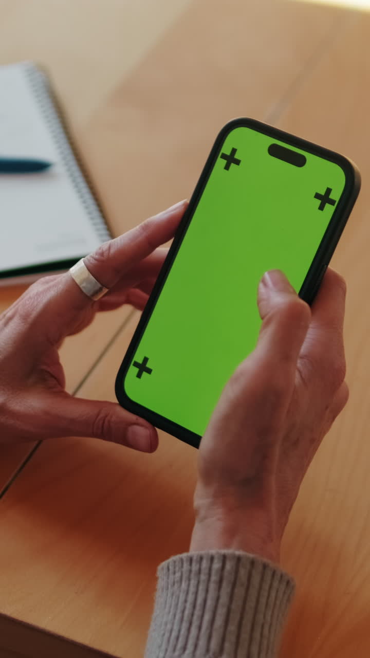 Primo piano di mani che usano uno smartphone con schermo verde