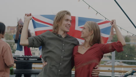couple celebrating with uk flag at rooftop party