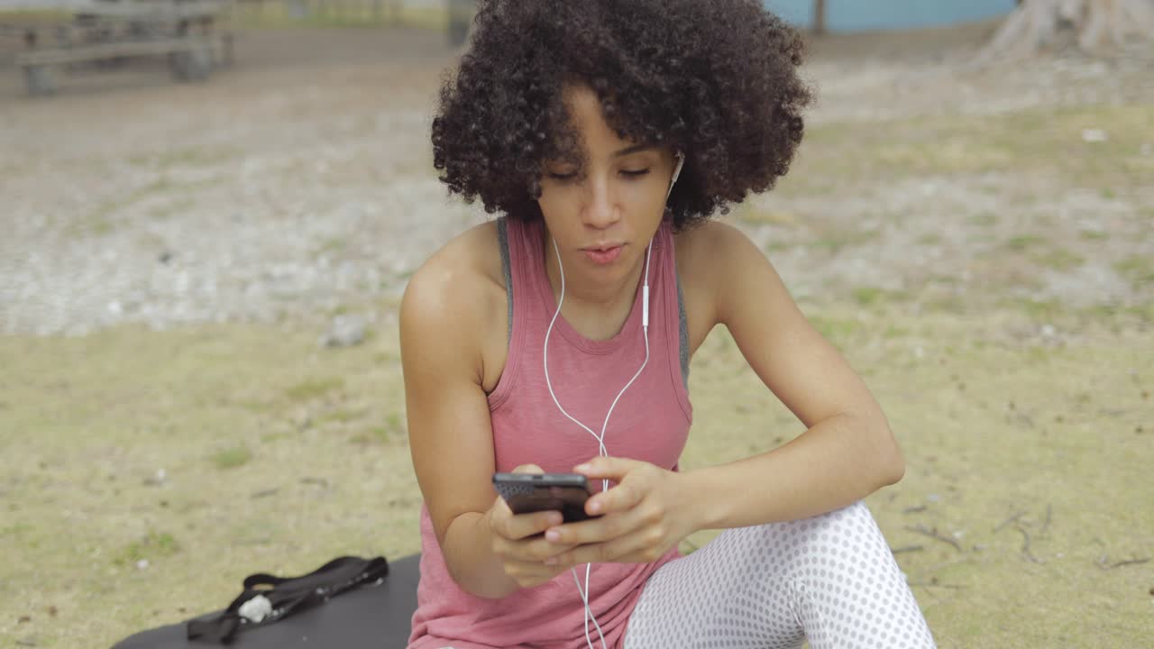 Woman speaking online sitting in park