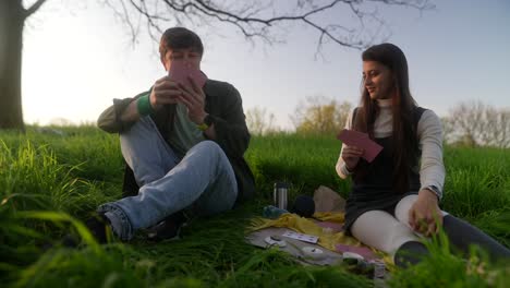 couple playing cards in a park at sunset