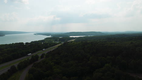 Establishing-aerial-shot-of-highway-road-with-trucks-driving-by-Arkansas-river