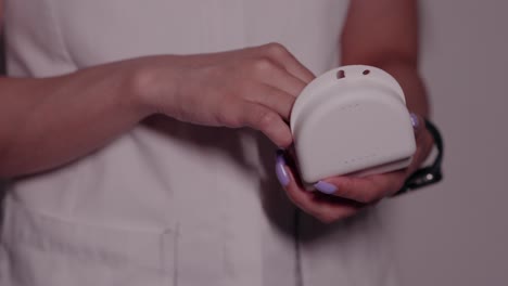 Doctor's-hands-with-purple-nails-holding-Invisalign-and-protective-case-close-up