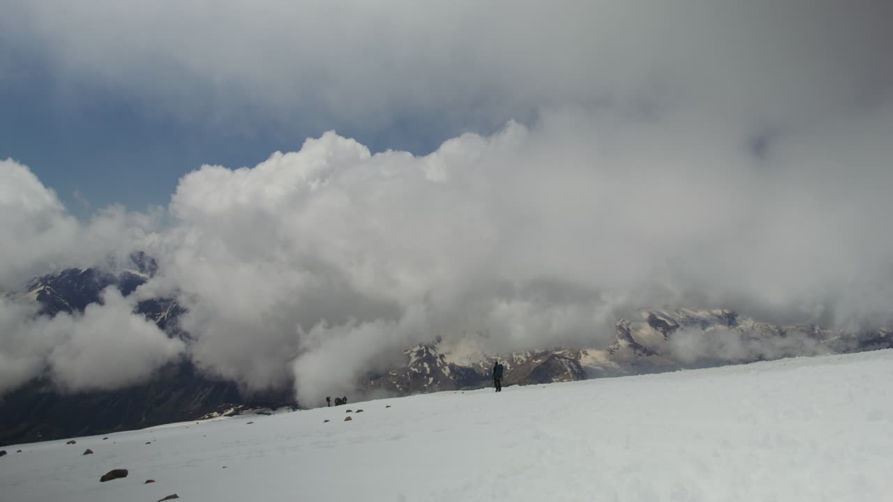 구름 이 있는 눈 인 산꼭대기 에 있는 산책자 들
