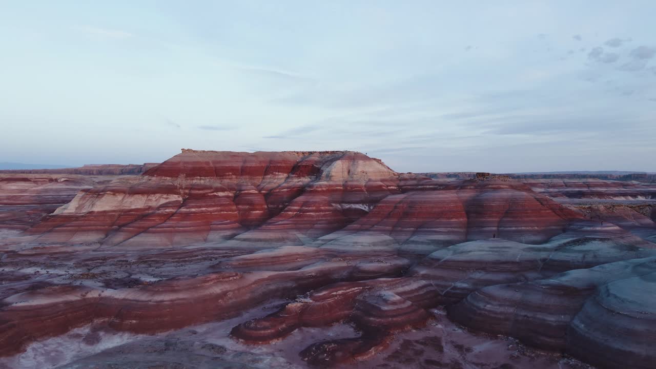 increíble elevación aérea con vistas al dramático contraste de la roca colorida de mesa en las colinas de bentonita hanksville utah durante la hora azul