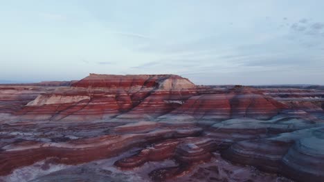 incredible aerial raise overlooking the dramatic contrast of colored mesa rock in bentonite hills hanksville utah during blue hour