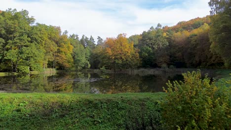 Un-Pequeño-Estanque-Que-Se-Extiende-En-Medio-De-Un-Bosque-Colorido-Durante-Los-Meses-De-Otoño