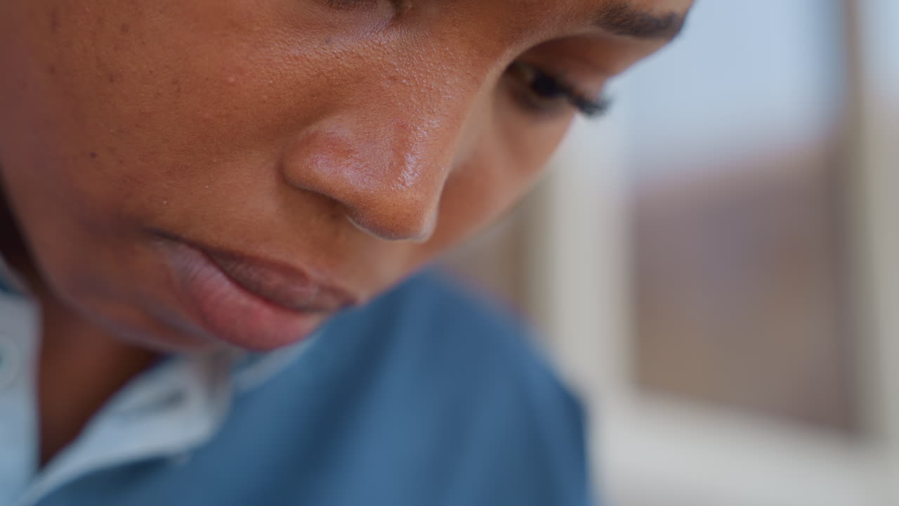 Black woman tasting fingertip while cooking at home, closeup on mouth and hands, blue shirt, intimate culinary moment, tasting and adjusting seasoning, domestic kitchen scene, mindful food prep