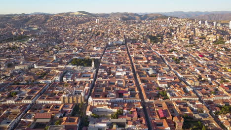 Vista-Aérea-Del-Atardecer-Sobre-Los-Techos-De-Tejas-Rojas-De-Sucre,-En-Las-Montañas-De-Los-Andes-De-Bolivia