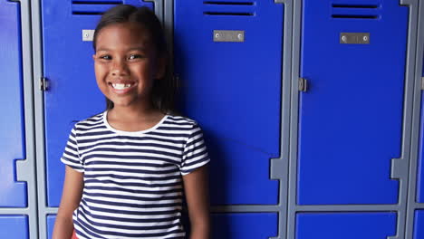 in a school hallway, a young biracial girl stands confidently with copy space