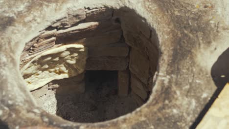 baking bread inside traditional tandoor oven at refugee camp