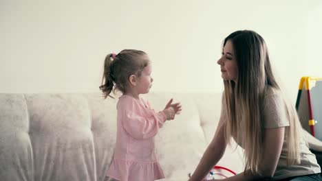 retrato de 4k madre joven y bebé dulce jugando hija le da a la madre una píldora de juguete