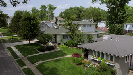 Aerial rise and push forward over nice houses in the suburbs on a pretty summer day