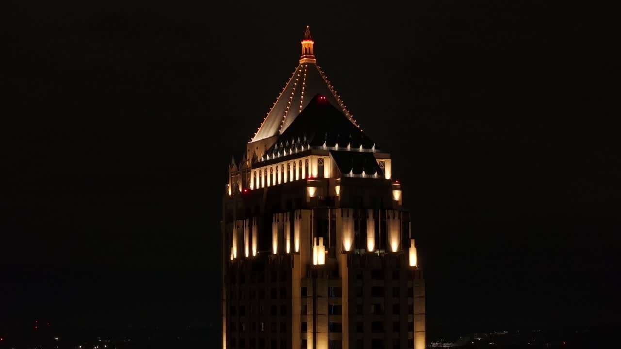 la parte superior del rascacielos iluminado por la noche