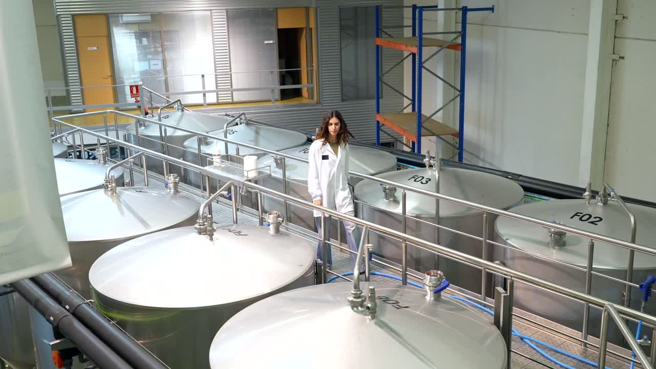 Woman in a lab working with stainless steel tanks