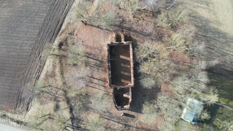 aerial top down descend over abandoned church wall outline remains