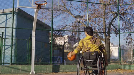 disabled man in wheelchair moving on basketball court.