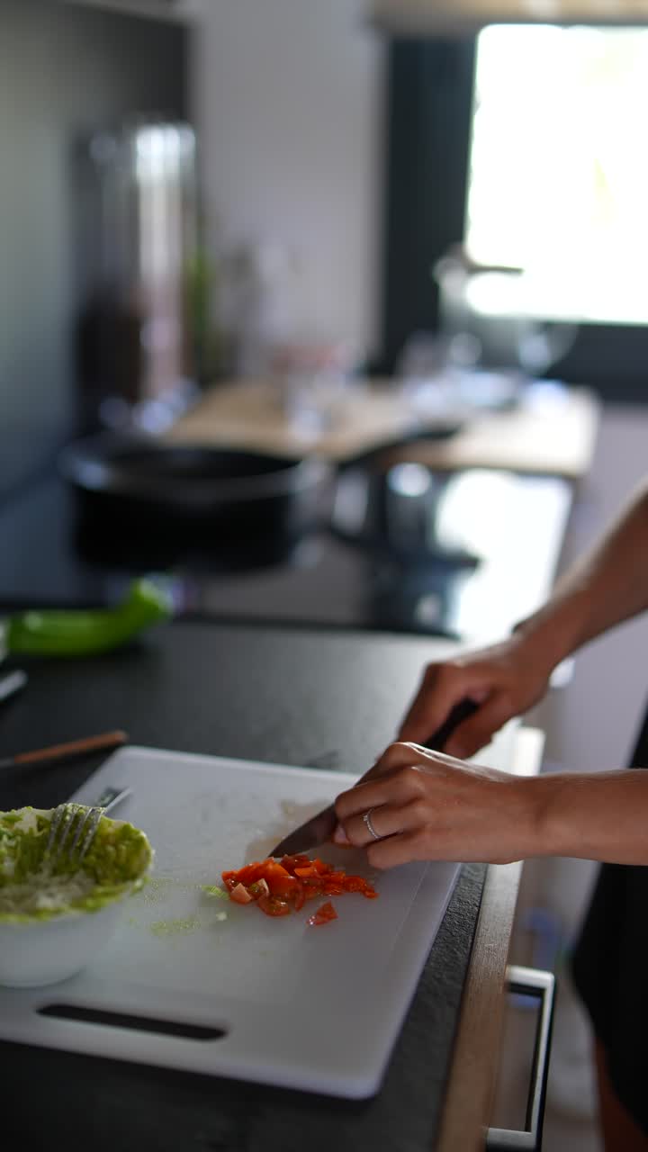 mujer cortando tomates en una cocina