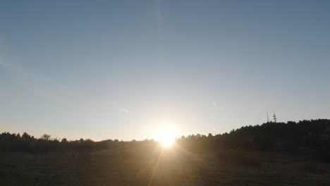 sol saliendo sobre una colina con una torre