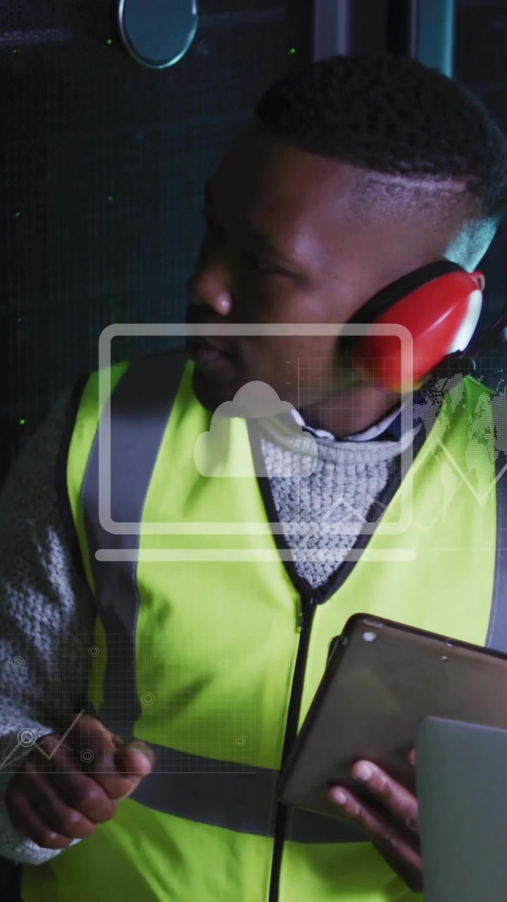 Vertical video: Technician using tablet in plant, HUD charts and cloud appearing monitoring data