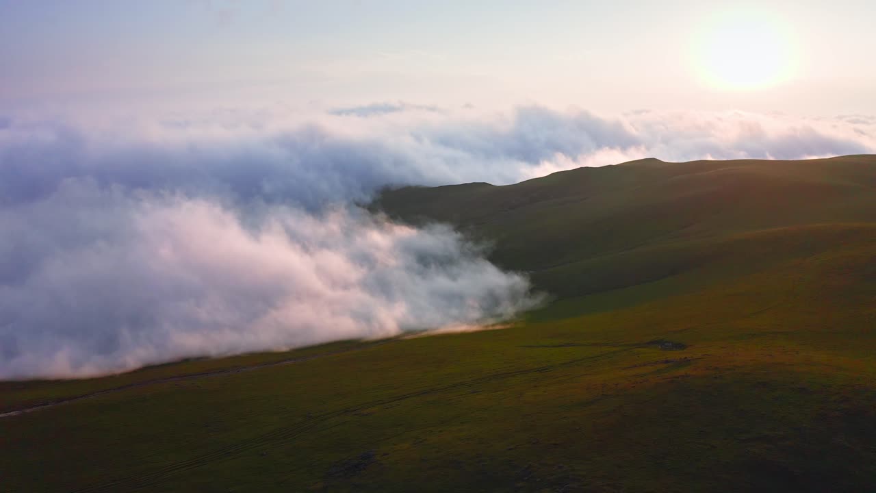nubes y niebla que se arrastran sobre el valle de la montaña al atardecer, vista aérea desde drones