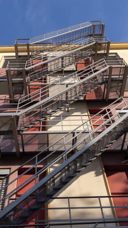 clouds passing over a cool industrial building, with exterior metal staircase in vertical