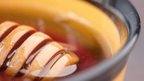 honey in a bowl with wooden dipper