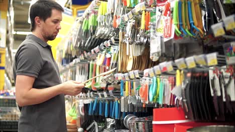 hombre comprando utensilios de cocina en una tienda de comestibles
