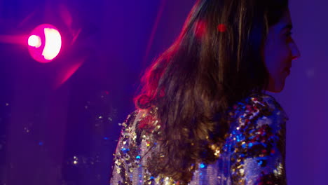 close up of woman in nightclub bar or disco dancing with sparkling lights 13