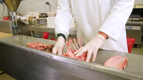 butcher arranging red meat on worktop