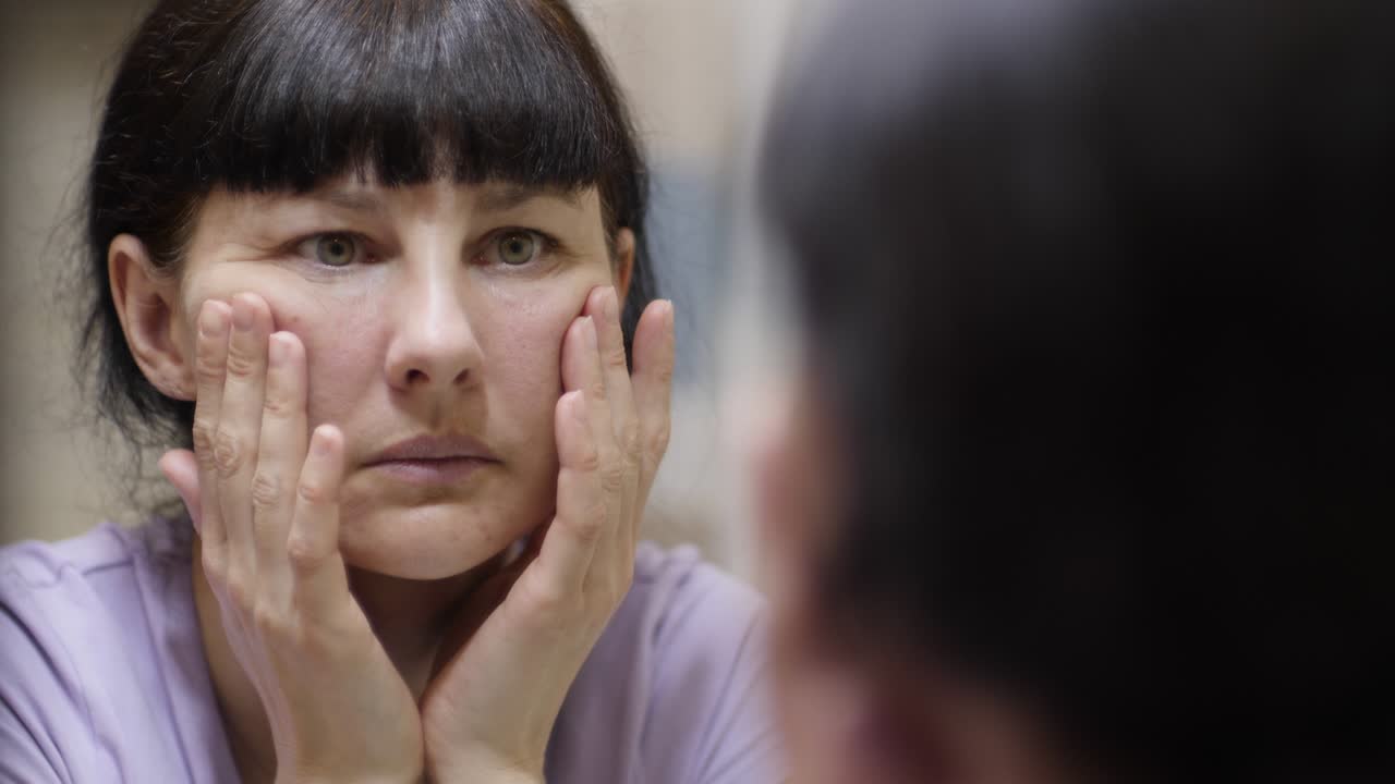 얼굴의 주름에 대해 혼란스러운 여성, 이마의 피부 노화, 거울을 보는 것, 얼굴 피부에 눈에 주름, 눈 주머니에 문제가있는 여성, 어두운 원, 주름, 스트레스, 우울증, 피로 다이어트.