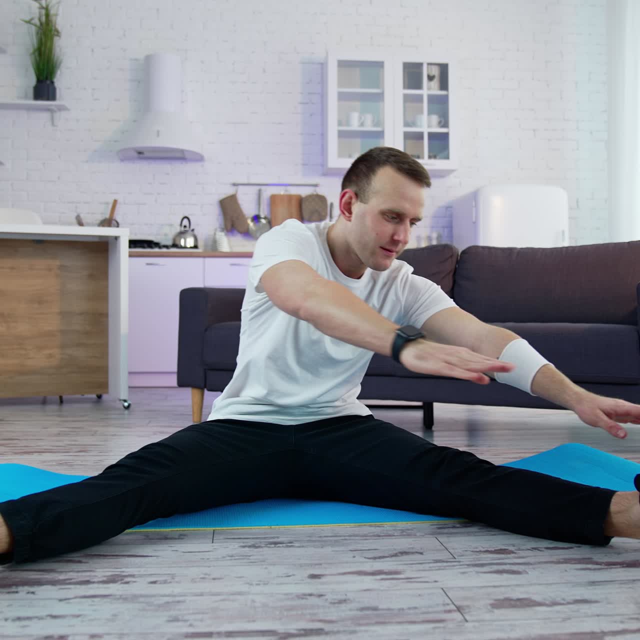 Young athletic healthy male training indoors. Strong man on quarantine working out in home