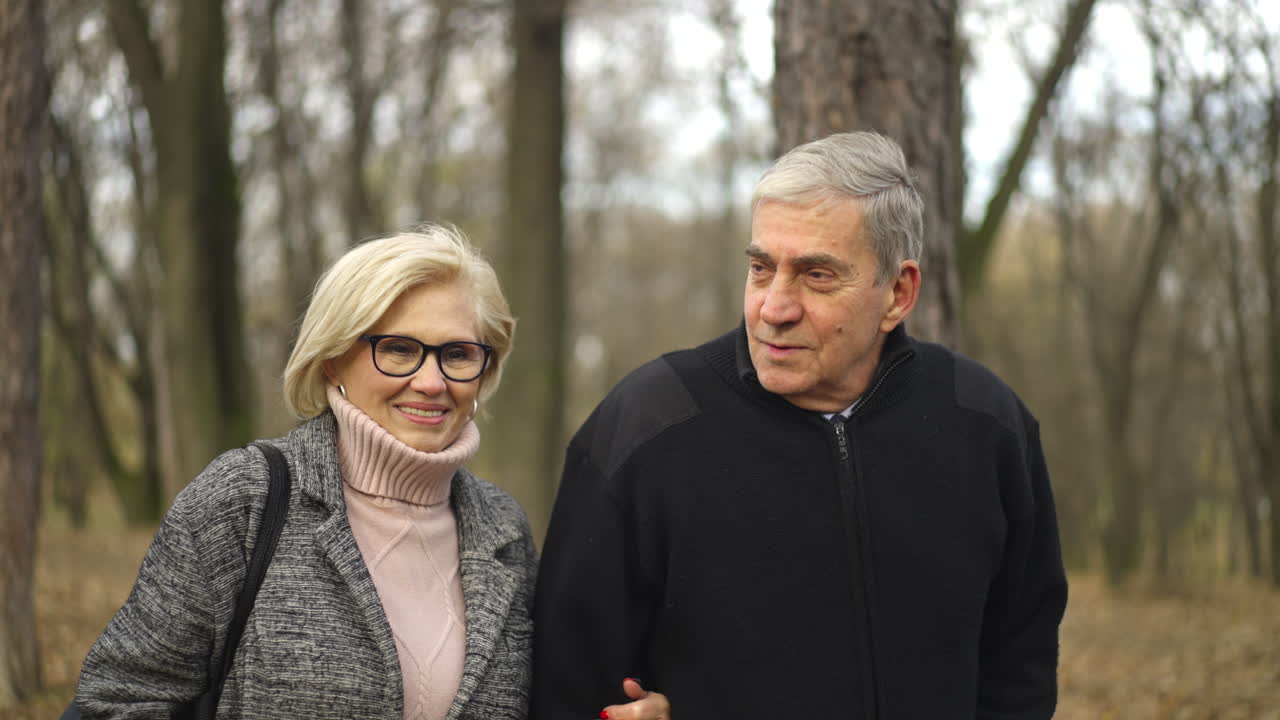 Older couple walking in the forest in autumn