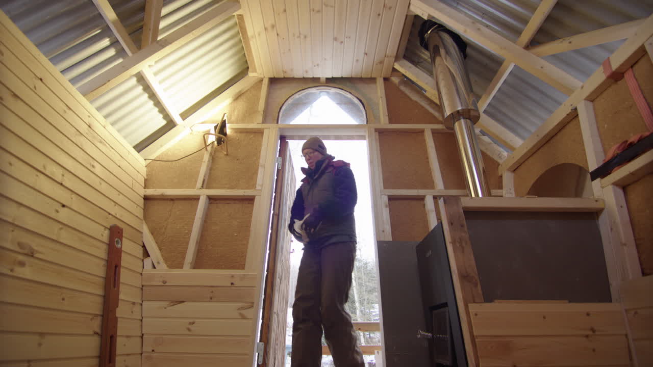 mujer de mano mide la sección del interior de la sauna de madera, construcción fuera de la red