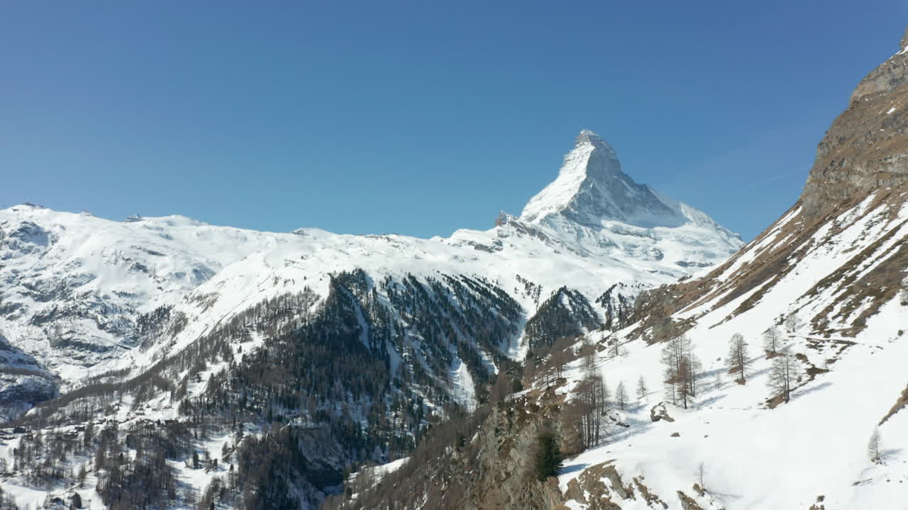 incline hacia arriba desde el borde de la montaña cubierta de nieve hasta un cervino distante