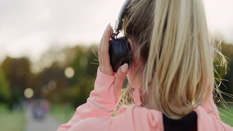 handheld video shows of woman listening to music by headphones