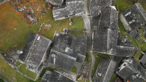 Toma-Aérea-De-Un-Dron-Moviéndose-Desde-Abajo-Hacia-Arriba,-Sobre-El-Pueblo-De-Cavergno,-Situado-En-El-Distrito-De-Vallemaggia,-En-El-Cantón-De-Ticino,-En-Suiza.