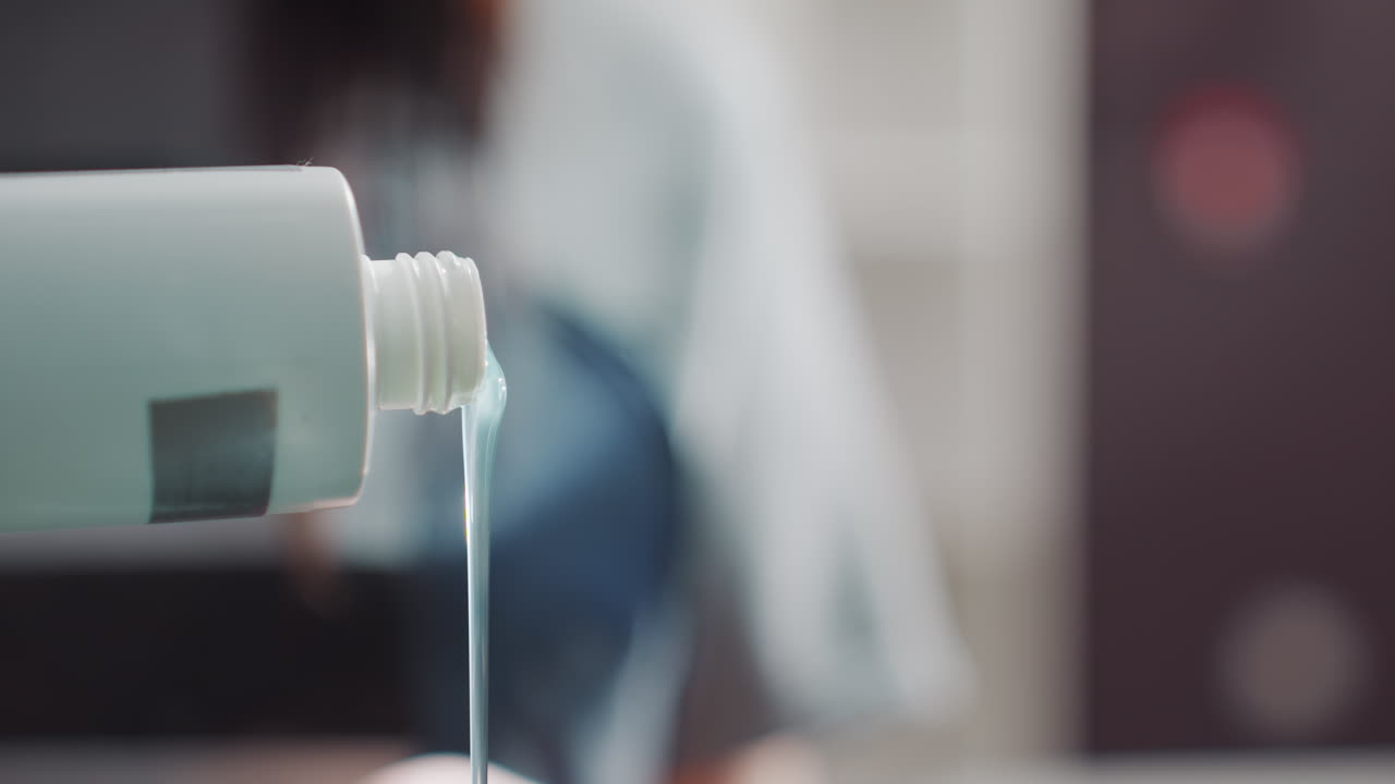 용기에 꾸준히 염료를 붓고, 배경에 집중하여 침착하게 기법을 유지하며, 정확성과 전문적인 정밀성을 강조하면서 용기에 색조를 조절하여 붓습니다.