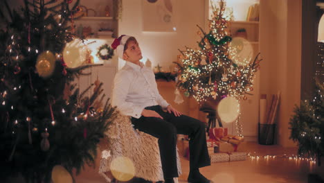 worried man sitting on chair at illuminated home during christmas