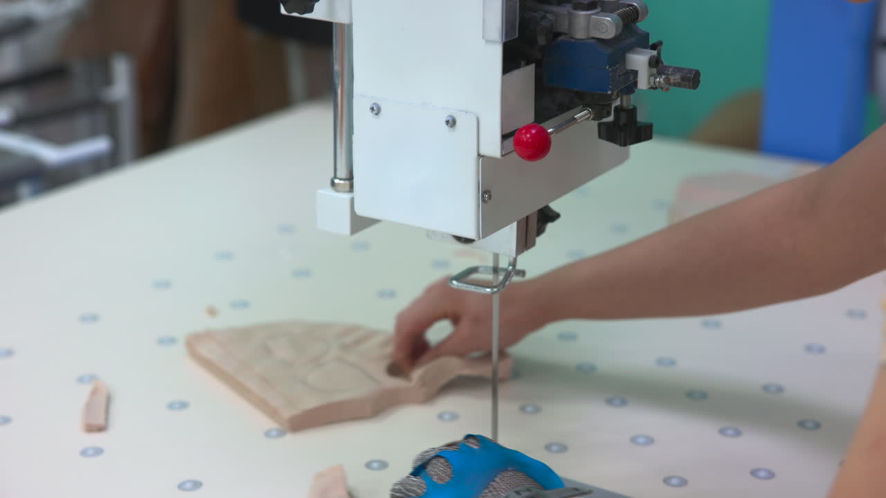 Precision Fabric Cutting With Industrial Machine. Operator Guides Material Under Vertical Blade On Dotted. Media