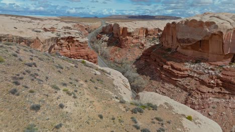 Enormes-Acantilados-Erosionados-De-Revelan-La-Carretera-Asfaltada-En-El-Parque-Nacional-Arches-En-Utah,-Estados-Unidos