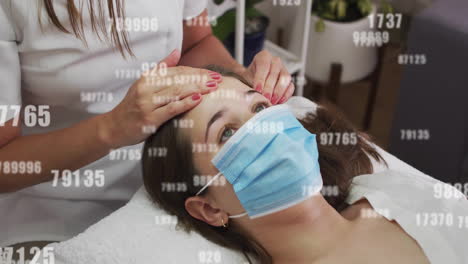 receiving facial treatment, woman wearing mask with numbers overlay animation