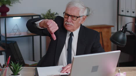 hombre de negocios senior molesto mostrando los pulgares hacia abajo gesto de señal, desaprobación, insatisfacción, disgusto