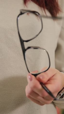 Individual is Elegantly Holding a Pair of Eyeglasses Emphasizing Stylish Eyewear Individual is Elegantly Holding a Pair of Eyeglasses Emphasizing Stylish Eyewear within a Contemporary Setting