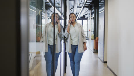 african american businesswoman talking on smartphone at office, in slow motion