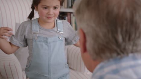 grandfather hugging granddaughter happy little girl embracing grandad enjoying affectionate hug from child sharing love gently holding grandparent at home