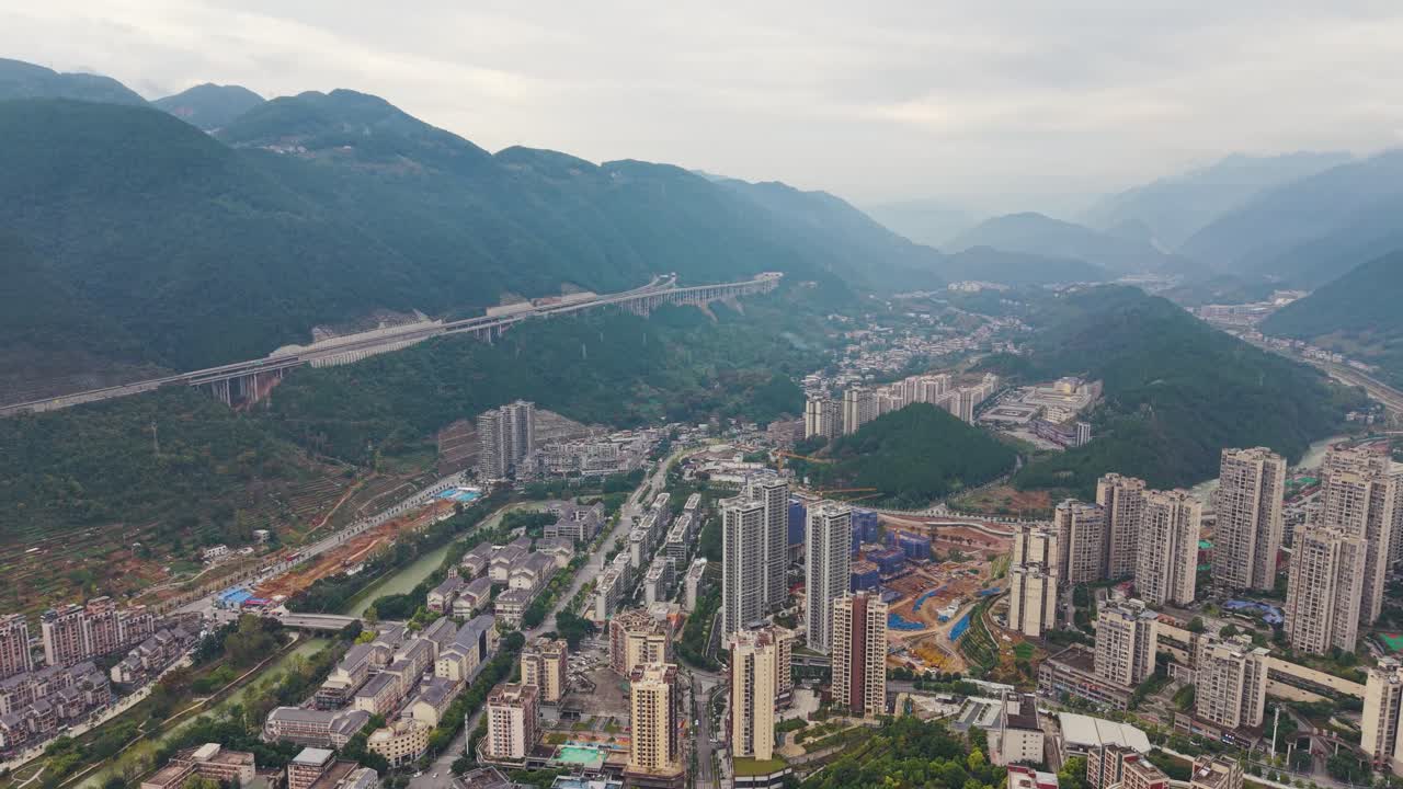 Aerial of the city skyline of Wuxi, China, with towering high-rise buildings set against scenic mountainous terrain. Concept of urban development, city planning, and tourism. UHD